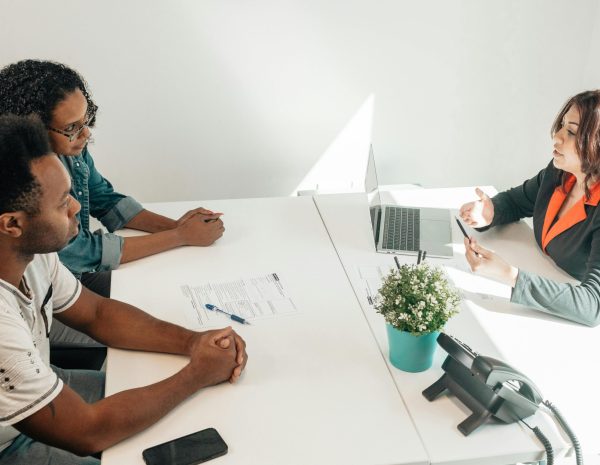 pexels-photo-7979439-7979439 Two adults consulting a legal advisor in a modern office setting.